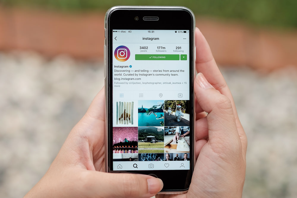 iPhone with instagram on the screen, held in a women's hand